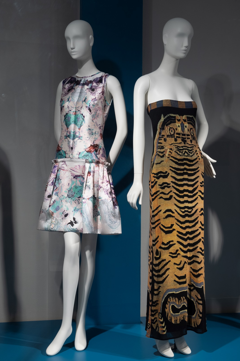 On left, a spring 2012 dress by Prabal Gurung with pale pink and blue imagery. On right, a spring 1998 dress by Vivienne Tam with tiger-inspired orange and black stripes.